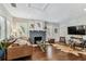 Bright living room featuring hardwood floors, plantation shutters, and fireplace at 711 S Bungalow Ter, Tampa, FL 33606