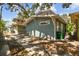 Charming side view of a blue shingle house featuring lush greenery and shade at 711 S Bungalow Ter, Tampa, FL 33606