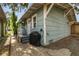 Side exterior shows the light blue wood siding, steps to porch, and grill, blending functionality with charm at 711 S Bungalow Ter, Tampa, FL 33606