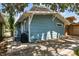 Charming side view of a blue shingle house featuring lush greenery and shade at 711 S Bungalow Ter, Tampa, FL 33606