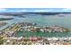 Expansive aerial view of waterfront homes, lush landscapes, and tranquil waterways in a vibrant coastal neighborhood at 760 Capri Blvd, Treasure Island, FL 33706