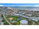 Sweeping aerial view showcases beachside community with waterfront access and recreational area featuring a baseball field and tennis courts at 760 Capri Blvd, Treasure Island, FL 33706