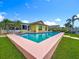 A stunning backyard showcasing a sparkling swimming pool, tropical landscaping, and a beautiful home, creating an oasis for relaxation at 760 Capri Blvd, Treasure Island, FL 33706