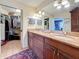 Double sink bathroom featuring granite countertops, dark wood cabinets, and view to a closet at 760 Capri Blvd, Treasure Island, FL 33706