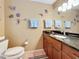Well lit bathroom with granite counters, cabinet storage, neutral tile, and themed decor at 760 Capri Blvd, Treasure Island, FL 33706