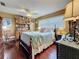 Inviting bedroom features a four-poster bed, wood floors, and built in shelving for storage and display at 760 Capri Blvd, Treasure Island, FL 33706