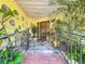 Inviting entryway with decorative tiles, plants, and a wrought iron railing leading to the front door at 760 Capri Blvd, Treasure Island, FL 33706