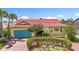 Charming home showcasing beautiful brickwork, tropical landscaping, and a striking red tile roof at 760 Capri Blvd, Treasure Island, FL 33706