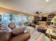 Spacious living room features a cozy seating arrangement, large windows, and a decorative rug at 760 Capri Blvd, Treasure Island, FL 33706