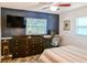 Bedroom with a navy accent wall, dresser, desk, and modern furnishings at 7699 92Nd St, Seminole, FL 33777
