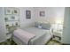 Cozy bedroom featuring decorative shelves, nightstand, and a soft gray bedspread at 7699 92Nd St, Seminole, FL 33777