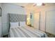 Bedroom with a gray tufted headboard, striped bedspread, and neutral decor at 7699 92Nd St, Seminole, FL 33777