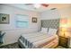 Bedroom with a gray tufted headboard, striped bedspread, and neutral decor at 7699 92Nd St, Seminole, FL 33777