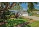 Charming single-story home featuring a lush front yard and a driveway leading to an attached garage at 7699 92Nd St, Seminole, FL 33777