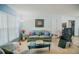 Bright living room featuring a comfortable sofa, tile flooring, and large window at 7699 92Nd St, Seminole, FL 33777