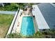Aerial view of fenced pool with lounge seating, outdoor dining set, mature landscaping, and backyard at 7699 92Nd St, Seminole, FL 33777