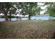 View of the large backyard with a shed, bordered by a white fence and mature trees, enhancing privacy at 8405 N Willow Ave, Tampa, FL 33604