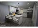 Modern kitchen with white cabinets, stainless steel appliances, a breakfast bar, and sleek gray flooring at 8405 N Willow Ave, Tampa, FL 33604