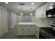 Beautifully renovated kitchen with modern appliances, a breakfast bar, white cabinetry, and stylish lighting at 8405 N Willow Ave, Tampa, FL 33604