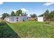 Backyard featuring green grass, white house, storage shed, and patio with seating at 8939 90Th Ave, Seminole, FL 33777