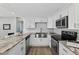 Modern kitchen featuring white cabinets, updated appliances, sleek hardware, and stone countertops at 8939 90Th Ave, Seminole, FL 33777