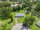 Aerial view of a home with a blue roof and a long driveway surrounded by lush green trees and lawns at 903 Dixie Maid Ln, Valrico, FL 33594
