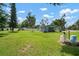 Large backyard with covered patio, green lawn, and storage sheds at 903 Dixie Maid Ln, Valrico, FL 33594