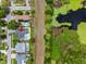 Aerial view of a charming home featuring a private pool and lush backyard adjacent to a serene lake with aquatic plants at 9109 134Th Way, Seminole, FL 33776