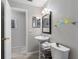 Bathroom with pedestal sink, glass shelving, and additional storage over the toilet at 9109 134Th Way, Seminole, FL 33776