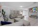 Spacious living room featuring tile floors, neutral furniture, and a large television at 9109 134Th Way, Seminole, FL 33776