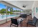 Covered and screened-in patio featuring brick flooring, pool view, and a hot tub at 9109 134Th Way, Seminole, FL 33776