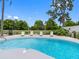 Sparkling kidney-shaped pool surrounded by lounge chairs, lush greenery, and a privacy fence for outdoor relaxation at 9109 134Th Way, Seminole, FL 33776