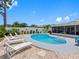 Backyard pool area surrounded by white fencing, lounge chairs and a screen-enclosed patio area at 9109 134Th Way, Seminole, FL 33776