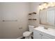 Cozy bathroom featuring floating shelves, neutral tones, and updated sink with modern fixtures at 932 Woodbridge Ct, Safety Harbor, FL 34695