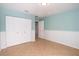 Bright bedroom with tiled floors, white closet doors, and wainscoting detail at 932 Woodbridge Ct, Safety Harbor, FL 34695