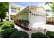 Bright home with a two-car garage, beautiful landscaping, and a cozy balcony, creating an inviting outdoor space at 932 Woodbridge Ct, Safety Harbor, FL 34695