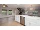 Open-concept kitchen with stainless appliances, white cabinets, hardwood floors, and a view into the expansive living area at 932 Woodbridge Ct, Safety Harbor, FL 34695