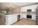 Modern kitchen with white cabinetry, stainless steel appliances, and a spacious island, ideal for cooking and gatherings at 932 Woodbridge Ct, Safety Harbor, FL 34695