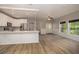 Open concept living space with white kitchen, light plank flooring, and ample natural light at 932 Woodbridge Ct, Safety Harbor, FL 34695