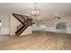 Spacious living room with light plank flooring, modern lighting and staircase with iron railings at 932 Woodbridge Ct, Safety Harbor, FL 34695