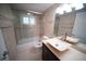 Modern bathroom with glass enclosed tub, stylish vanity, and tiled walls at 105 E North Branch Rd, Ruskin, FL 33570