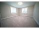 Bright, empty bedroom with neutral carpet, two windows with white shutters, and a flush mount light fixture at 105 E North Branch Rd, Ruskin, FL 33570