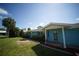 Charming home with a covered front porch, lush landscaping, and a bright blue exterior at 105 E North Branch Rd, Ruskin, FL 33570