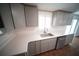 Bright kitchen featuring gray cabinets, stainless steel appliances, and a white countertop with stainless steel sink at 105 E North Branch Rd, Ruskin, FL 33570