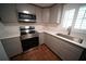 Updated kitchen features stainless steel appliances, gray cabinetry, white countertops, and wood-look flooring at 105 E North Branch Rd, Ruskin, FL 33570
