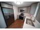 Updated kitchen features stainless steel appliances, gray cabinetry, white countertops, and wood-look flooring at 105 E North Branch Rd, Ruskin, FL 33570
