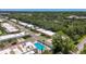 Aerial view of a community with a swimming pool, lush trees and well-maintained streets at 1102 Cara Dr, Largo, FL 33771
