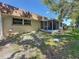 Exterior view of the rear of the home showing the screened-in patio and yard at 1102 Cara Dr, Largo, FL 33771