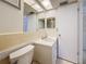 Well-lit bathroom with white vanity, toilet, mirror, and a door to another room at 1102 Cara Dr, Largo, FL 33771