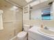 Bright bathroom featuring a shower, white vanity, and a large mirror reflecting the doorway at 1102 Cara Dr, Largo, FL 33771